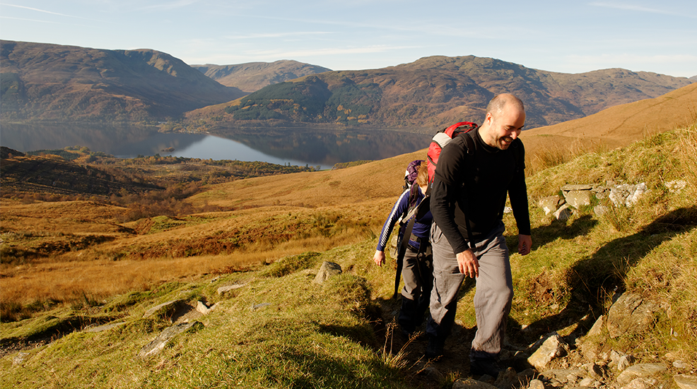 Two young people approaching the summit of Ben Lomond, Scotland, in Autumn
